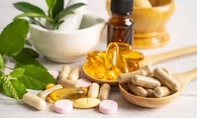 Vitamin capsules and supplement jars on a bright surface